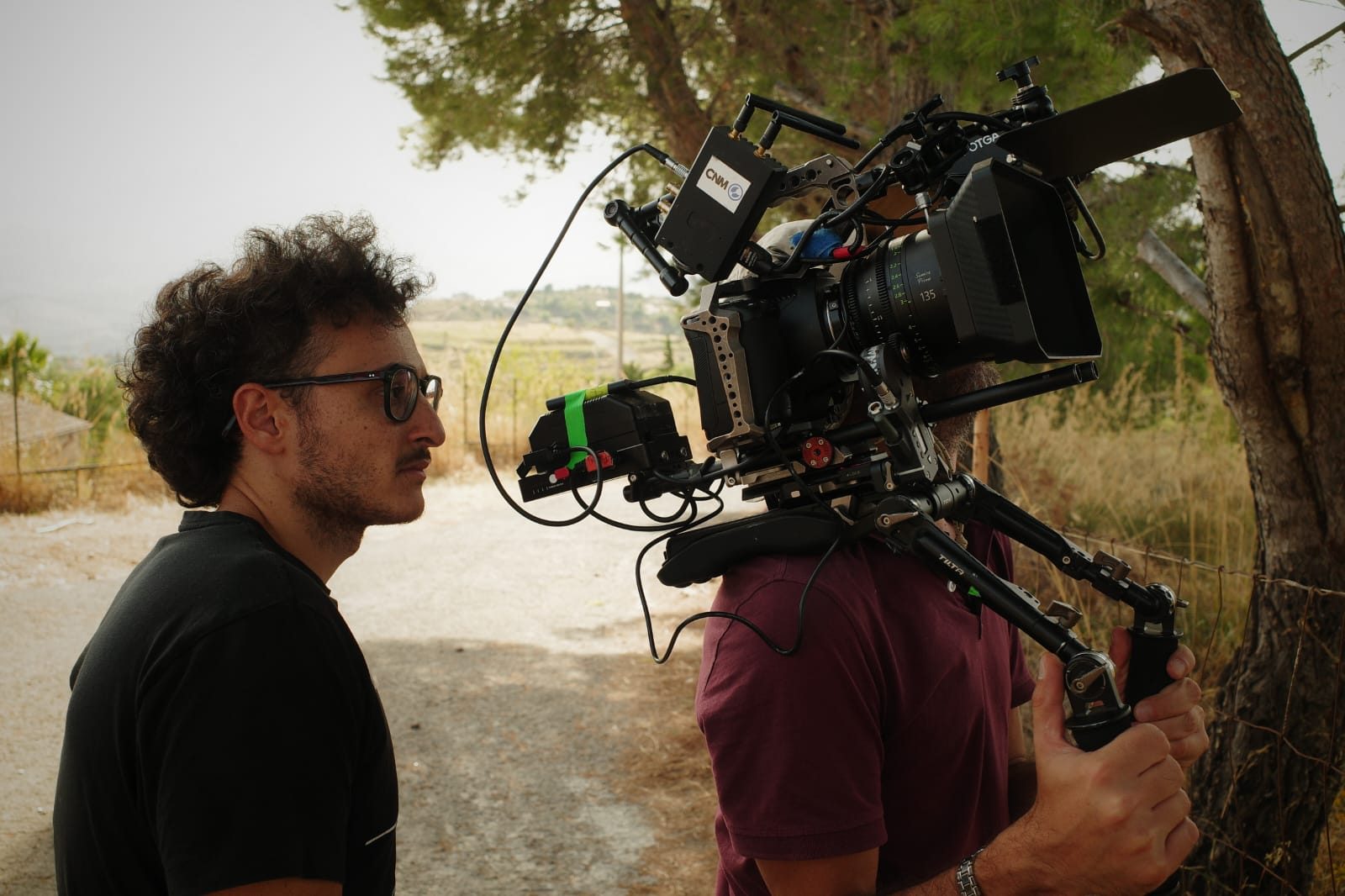 Gaetano Di Gaetano guarda il monitor accanto all’operatore di macchina, in campagna.