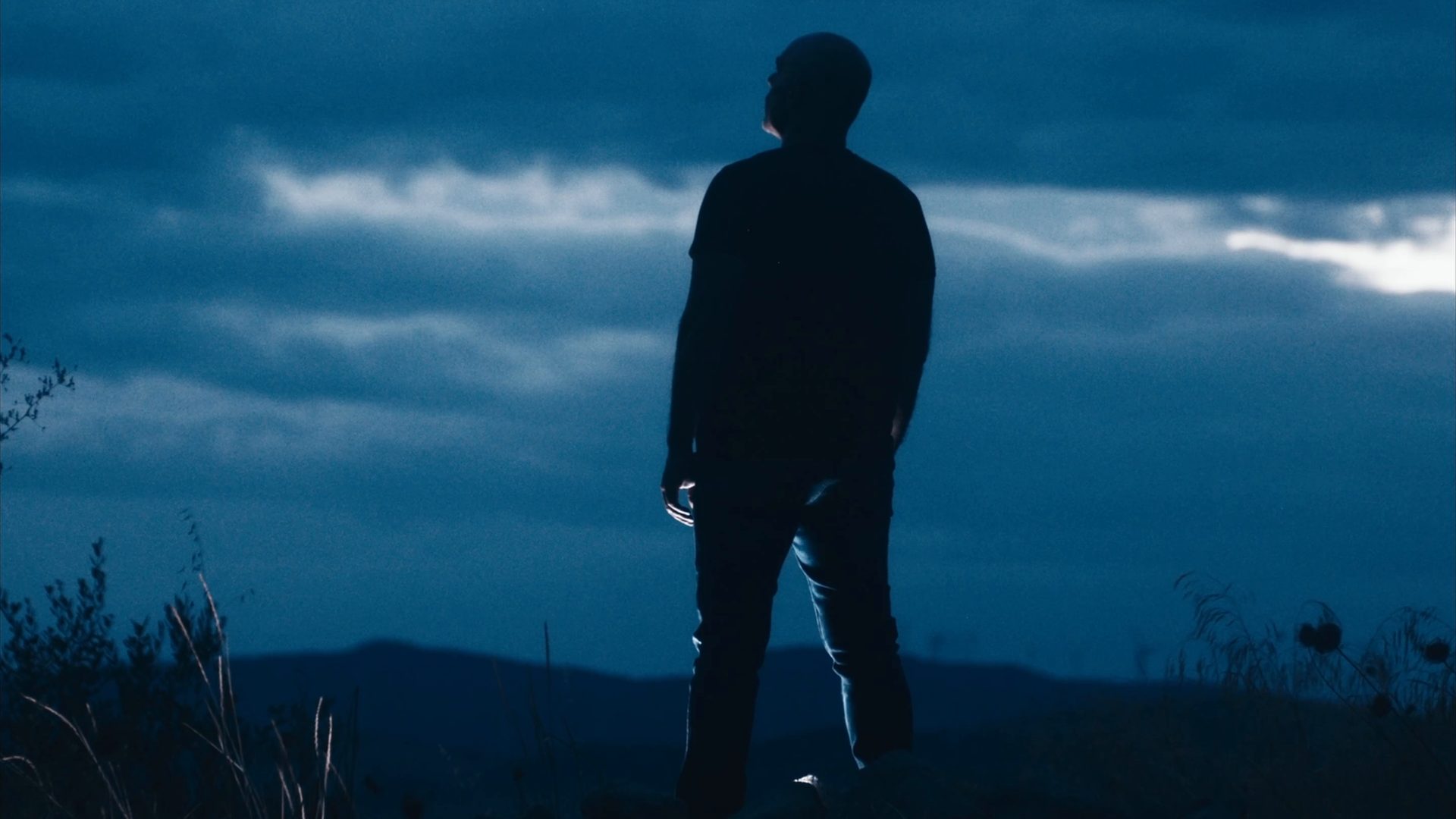 Un uomo in controluce su una collina, al crepuscolo. Fotogramma dallo showreel.